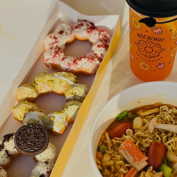 A box of Mochi donuts, a MochiNut drink, and ramen noodles with toppings.
