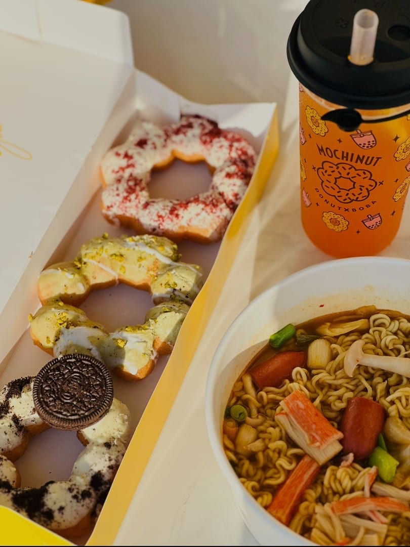 A box of Mochi donuts, a MochiNut drink, and ramen noodles with toppings.