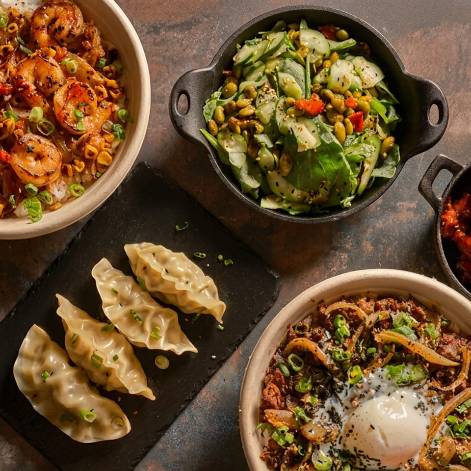 An overhead view of various Asian dishes, including shrimp, dumplings, salad, and beef bowls.